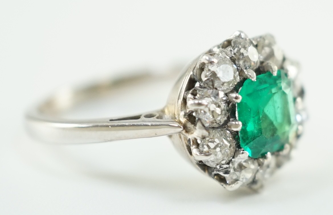 An early to mid 20th century, platinum, octagonal cut emerald and round cut diamond set circular cluster ring